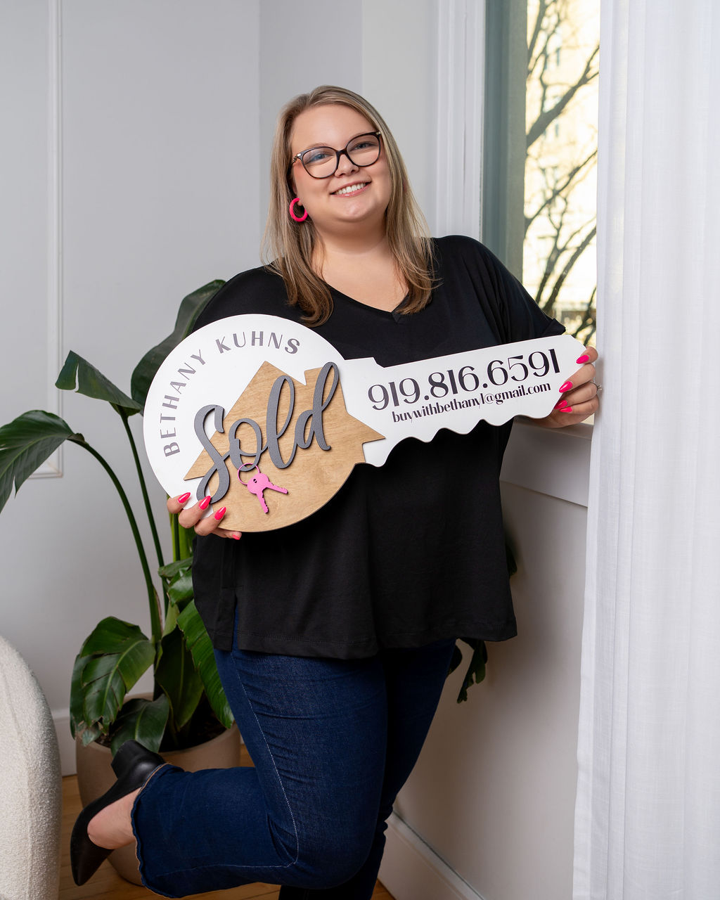Bethany Kuhns holding a sold key sign